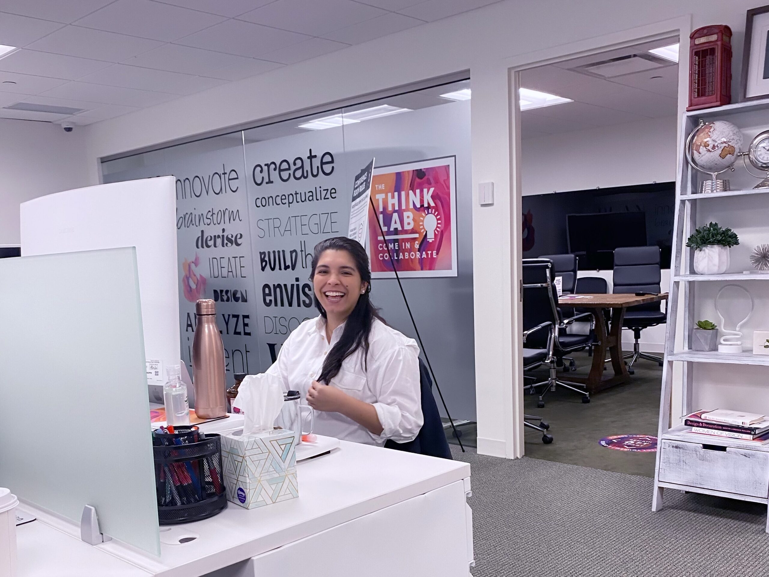 Copy & Art employee smiles at her desk at the White Plains office